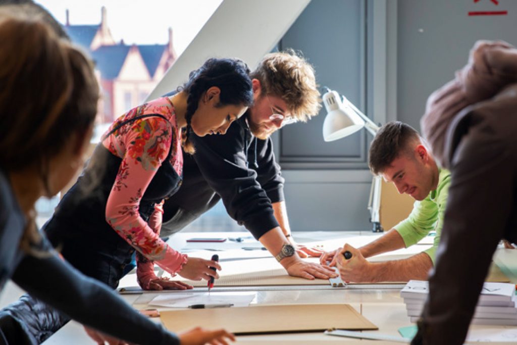 Students drawing and sketching on a table